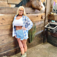 Blonde first timer unveils her large tits while getting naked at a horse farm