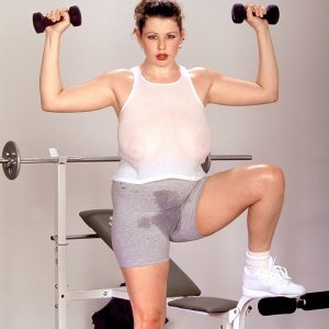 Desirae, a brunette MILF, reveals large natural breasts in an intense, sweat-filled workout