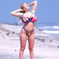 Golden-haired solo model Kayla Kleevage uncovers her faux boobies from a bathing suit while at the beach